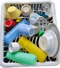 a white dish rack filled with plastic cups and utensils